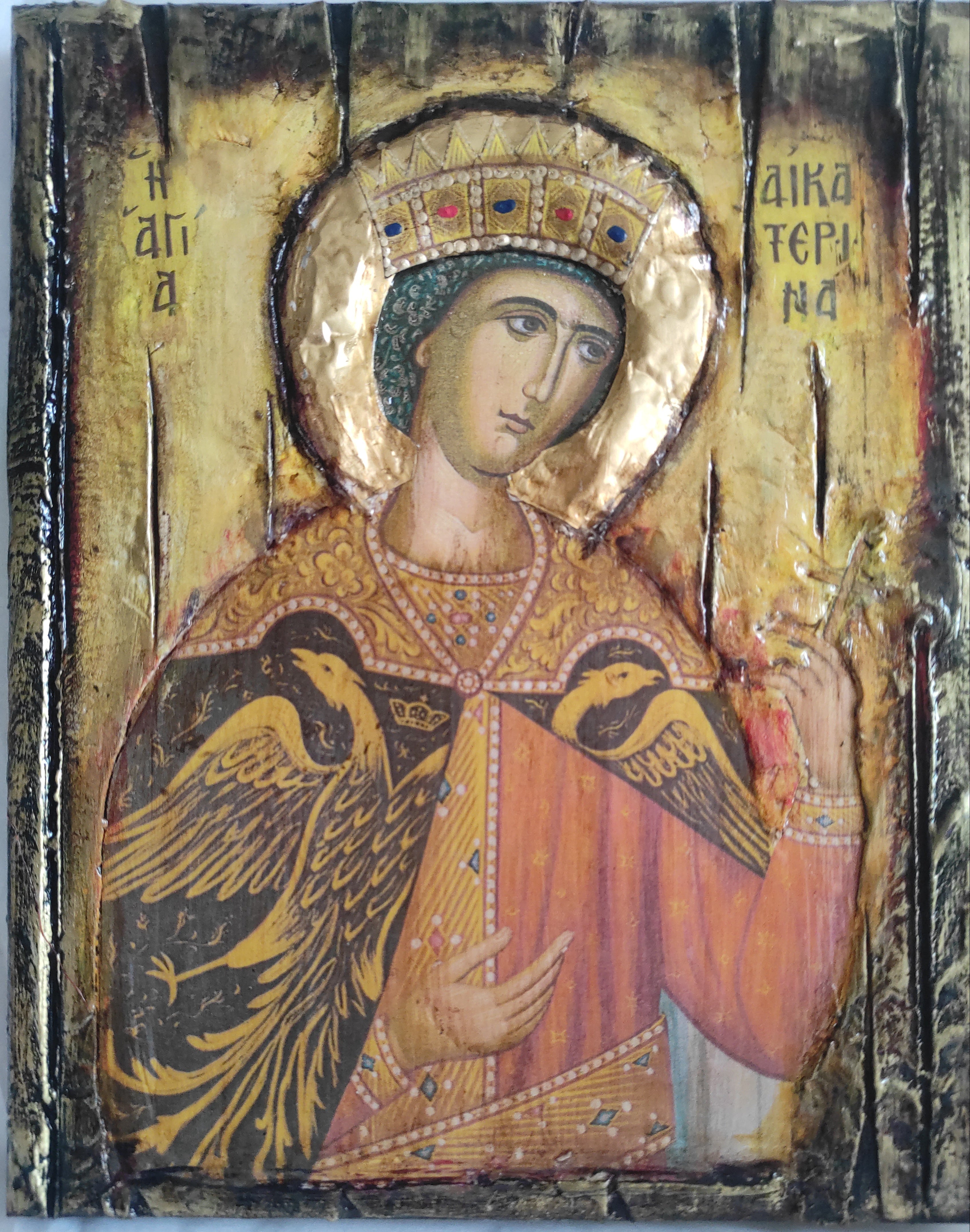 A Byzantine-style religious icon painting on a rectangular wooden panel, depicting a crowned saint or angel with a gold halo, ornate robe, and two black birds on the shoulders, set against a textured gold background with Greek lettering.