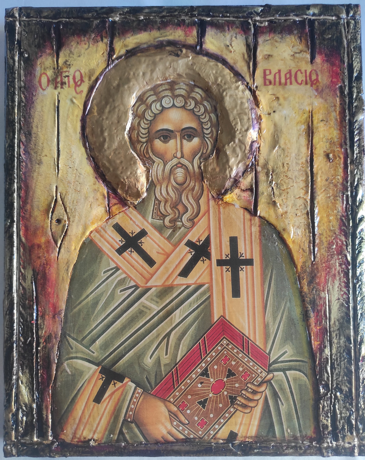 An antique-style religious icon design of Saint Vlasios, featuring a textured gold background, a halo, and a figure in green and orange robes holding a book, with Cyrillic inscriptions at the top.