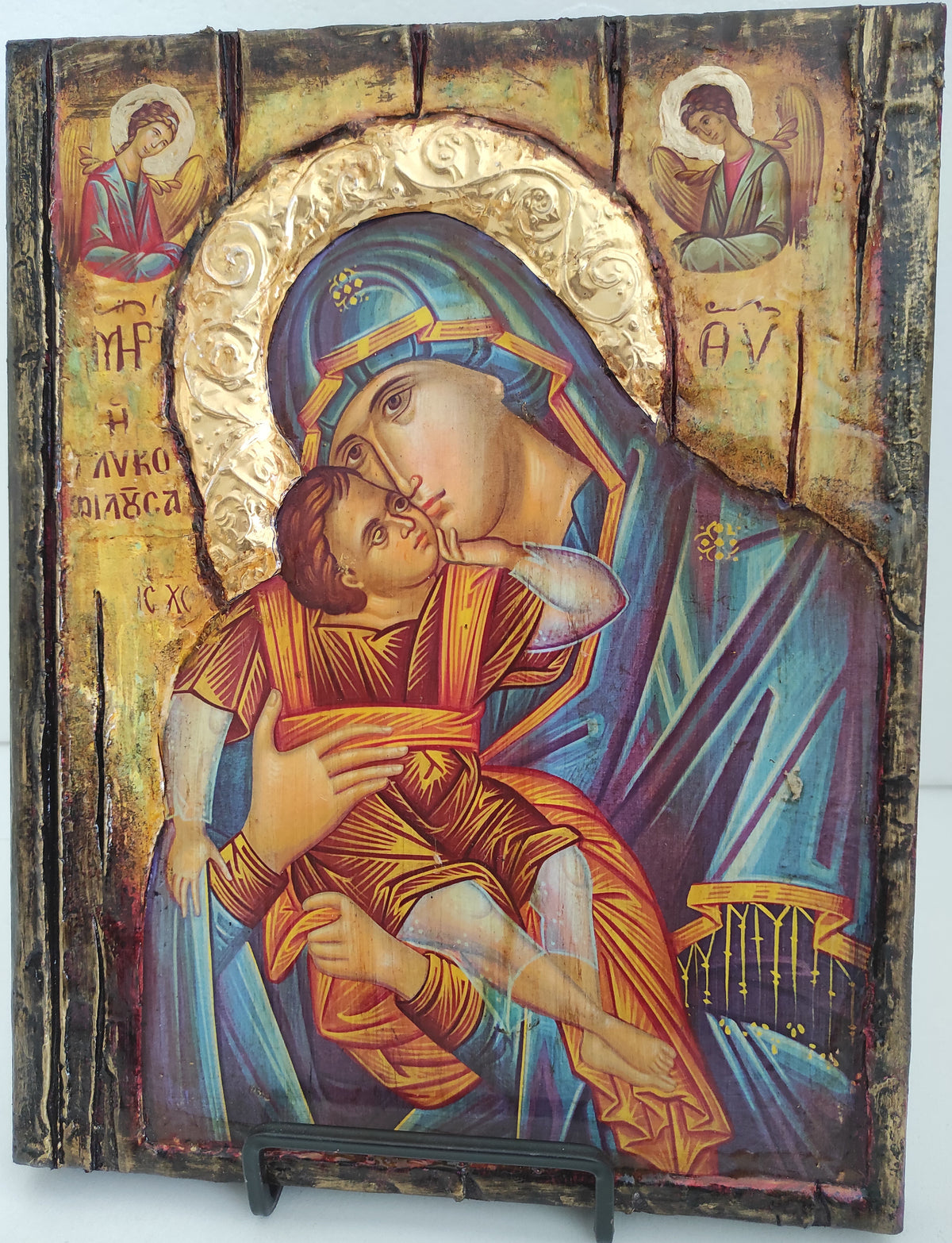 An antique-style wooden religious icon design depicting the Holy Family, featuring a distressed wood texture with gold leaf accents and a dark metal clasp on the right side.